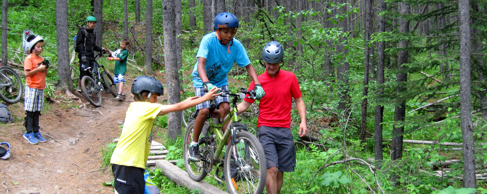 child mountain biking on log