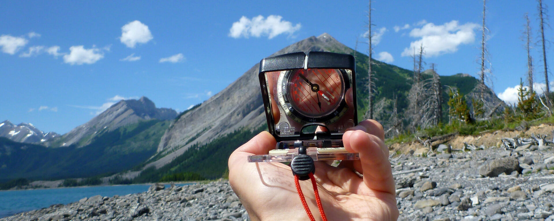 compass viewed against mountains in backdrop