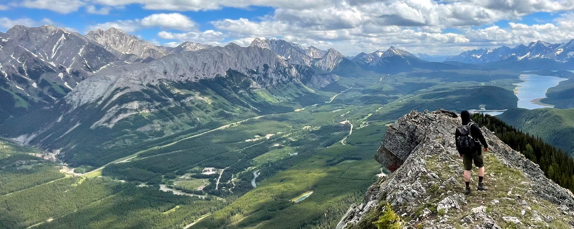 hiker on ridge overlooking forested valley