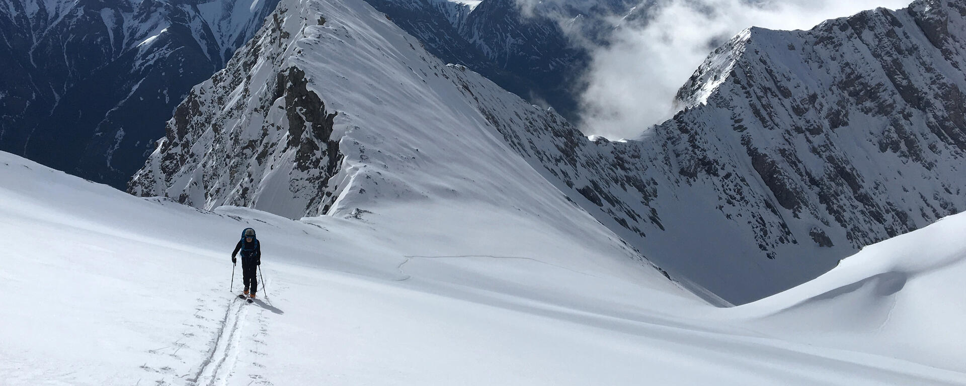 skier ascends crusty slope