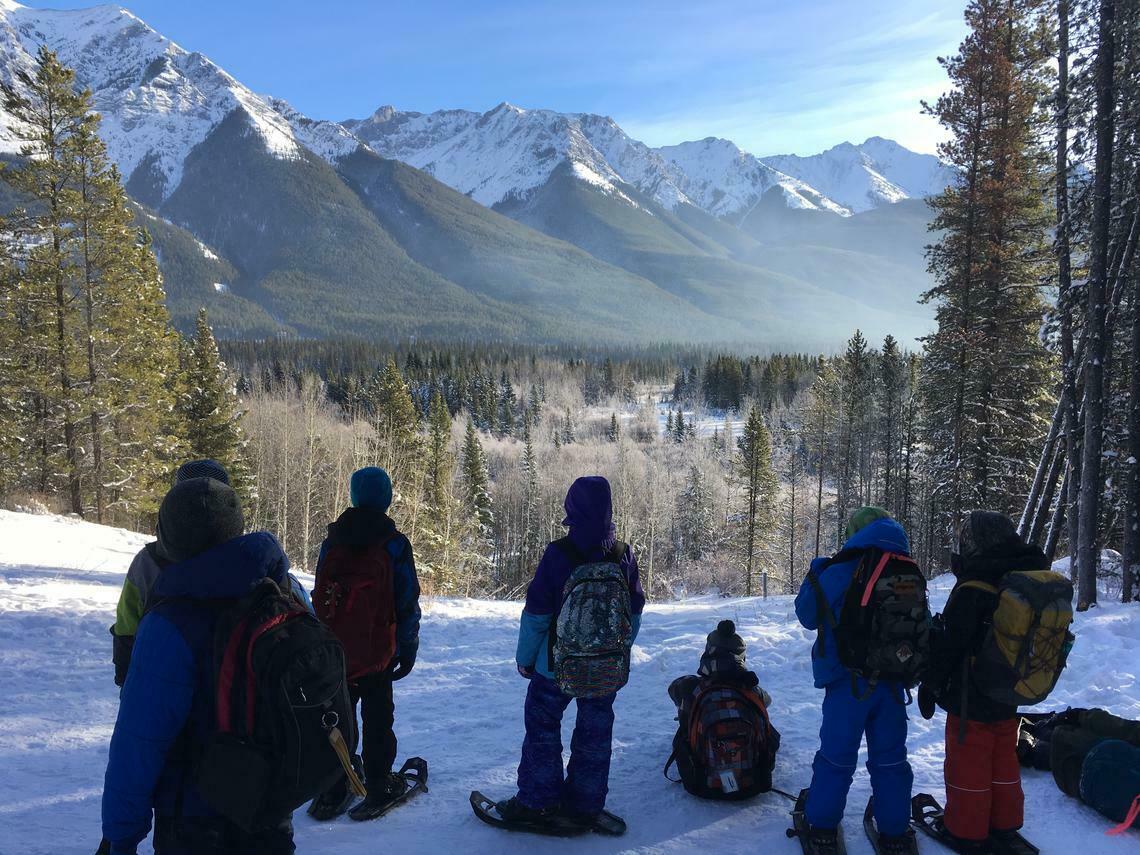 children on snowshoes overlooking valley view