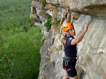 climber ascending wall on top rope