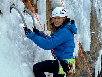 ice climber on toprope looks at photographer