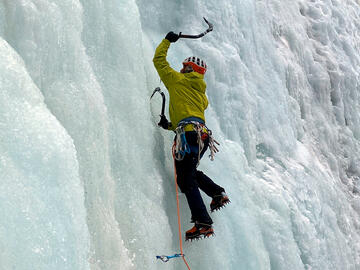 climber ascends on backdrop of ice