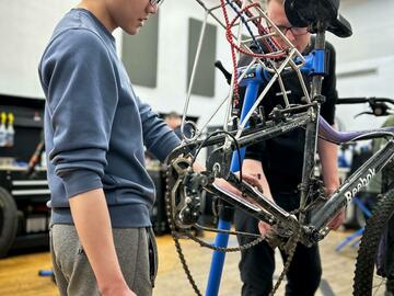 two people work on a bicycle