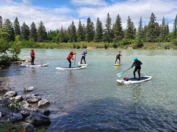 SUP paddlers on river eddy