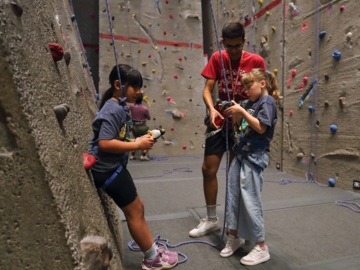 Instructor assisting youth climbers