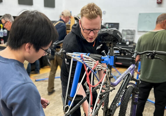 two men look at bike parts
