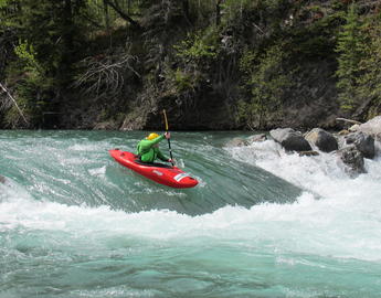 photo of kayaker on whitewater wave